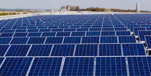 A worker checks solar panels on the roof of Conergy's solar panel plant in Frankfurt an der Oder on April 22, 2009