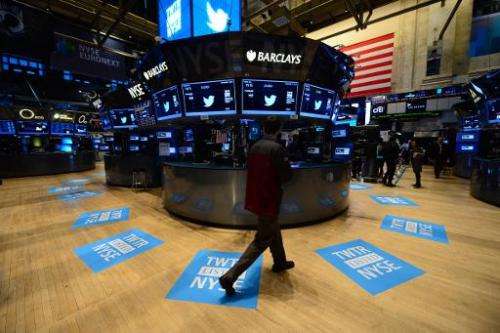 A worker stands walks near floor mats bearing the logo of Twitter and the company's TWTR stock symbol at the New York Stock Exch