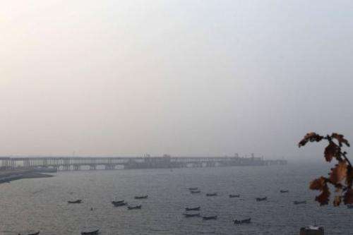 Boats berth in the waters near the Dalian Fujia Dahua Petrochemical factory in Dalian, China on January 18, 2013