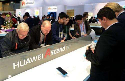 Consumers look at products at the Huawei booth at CES in Las Vegas on January 10, 2013