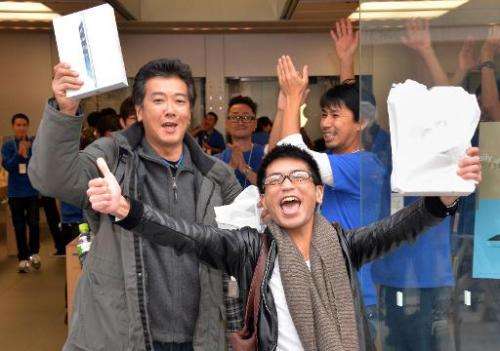 Customers celebrate after buying Apple's new iPad Air tablets at an Apple store in Tokyo on November 1, 2013