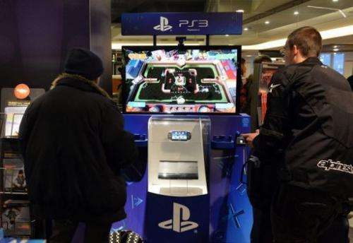 Customers have a go on a PlayStation 3 game console on November 27, 2012 in a Paris store
