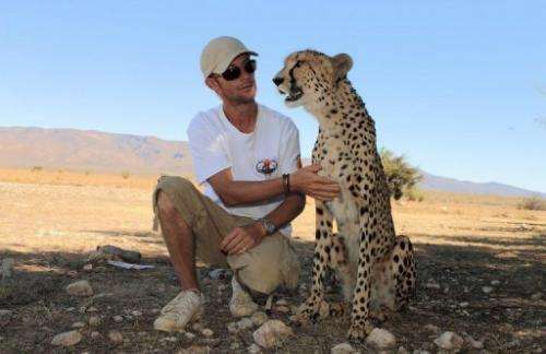 Damien Vergnaud poses with a cheetah on March 22, 2013 at his private game reserve north of Cape Town