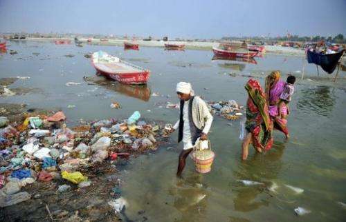 Devotees cross the polluted waters of the Ganga river to take a holy dip at Sangam in Allahabad on April 14, 2013