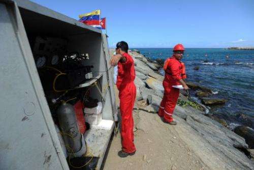 Divers work on the installation of a fiber optic cable between Venezuela and Cuba on January 22, 2011