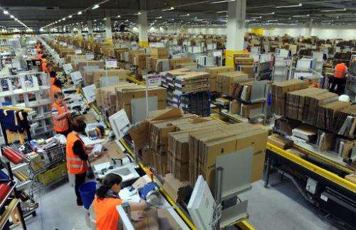 Employees pack parcels at the logistics centre of Amazon in Bad Hersfeld, central Germany, on December 20, 2010