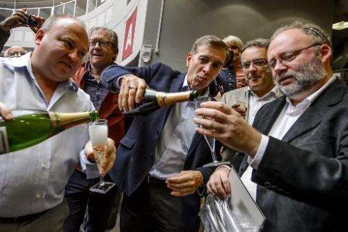 European Organisation for Nuclear Research (CERN) scientists celebrate with champagne after the annoucement of the winners of th