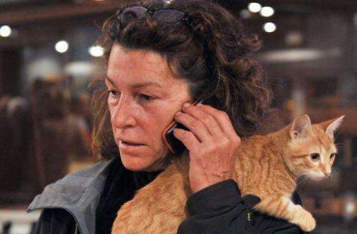 French yachtswoman Florence Arthaud makes a call with her cat on her shoulder in Marseille on October 31, 2011