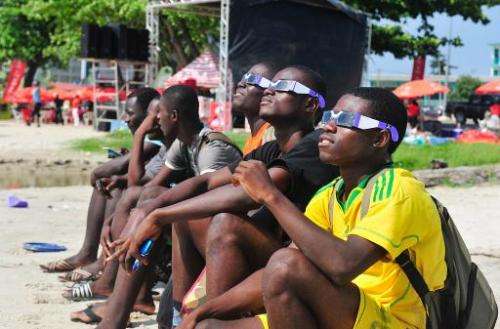 Gabonese people look at a rare solar eclipse through special glasses, on November 3, 2013 in Libreville