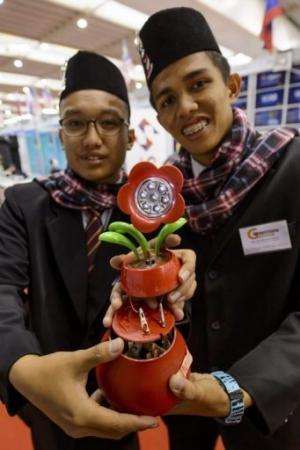 Hafizuddin Abdul Rahman (L) and Ahmand Syafiq Amirudin presents their invention in Geneva on April 10, 2013
