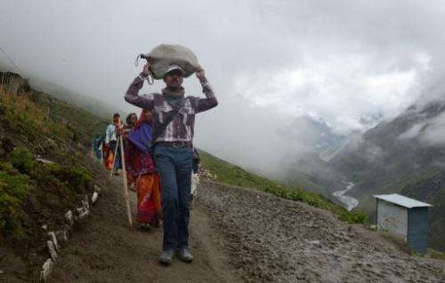 Hindu piligims walk past a latrine along the track to the Amarnath cave shrine on August 18, 2013