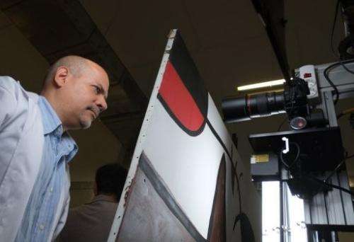 Humberto Duran of Reina Sofia Museum in Madrid monitors a robot taking pictures of a Miro painting on July 4, 2013