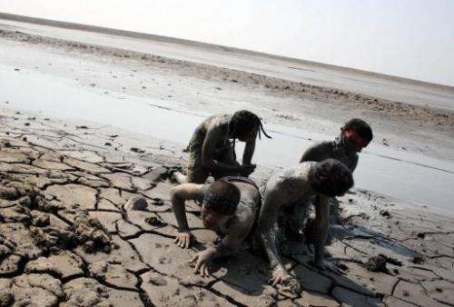 Indonesian activists cover themselves in sludge from a mud volcano during a protest in Porong village on May 29, 2011