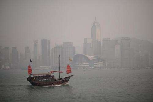 In this file picture taken on April 15, 2013, a junk sails past the Hong Kong skyline which is shrouded in a dense blanket of to