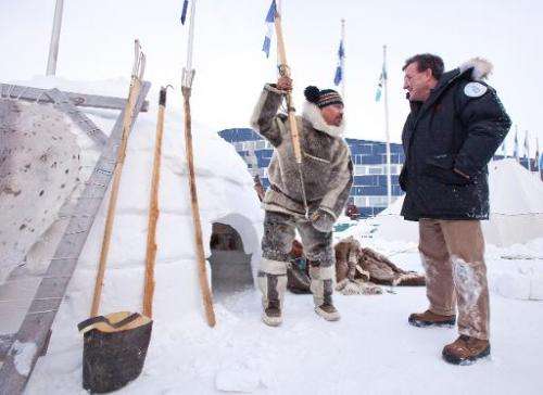 Inuit hunter Pitseolak Alainga (left) explains seal hunting to Canada's Finance Minister Jim Flaherty in Iqaluit, Canada on Febr