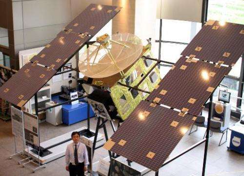 Japan Aerospace Exploration Agency (JAXA) associated professor Makoto Yoshikawa displays the full-scale model of Japan's space p