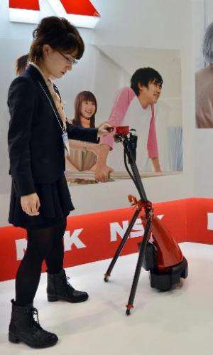 Japan's auto parts maker NSK demonstrates a cane style navigation 'LIGHBOT' robot for elderly and handicaped people, equipped wi