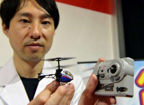 Japan's toy maker CCP employee shows a toy helicopter, &quot;Nano-Falcon,&quot; in Tokyo, on June 13, 2013
