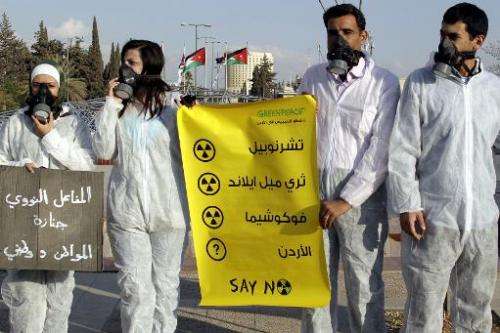 Jordanian Greenpeace activists protest outside the premier's office in Amman on October 30, 2011 against the country's official 