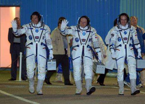 L-R: American astronaut Michael Hopkins and Russian cosmonauts Oleg Kotov and Sergei Ryazansky walk to their bus after at the Ba
