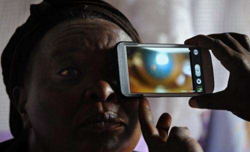 Mary Wambui gets her eyes examined at her home in Kianjokoma village, on August 28, 2013