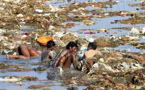 Men hunt coins and gold in the polluted Ganga river at Sangam on April 2, 2013 after the Kumbh Mela festival