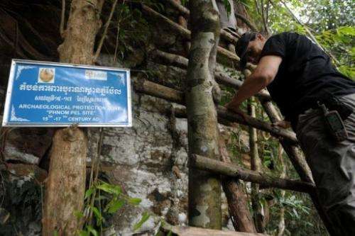 Nancy Beavan, an archaeologist who specialises in carbon dating, climbs up a cave at Phnom Pel on March 24, 2013