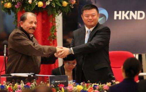 Nicaraguan President Daniel Ortega (L) shake hands with Wang Jing, president of HKND Group in Managua, on June 14, 2013