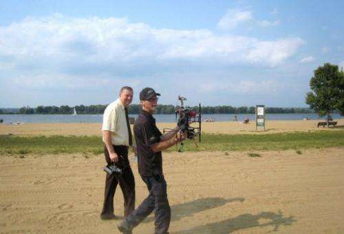 Ottawa city councilor Bob Monette (L) and hexacopter owner Steve Wambolt walk at Petrie Island beach
