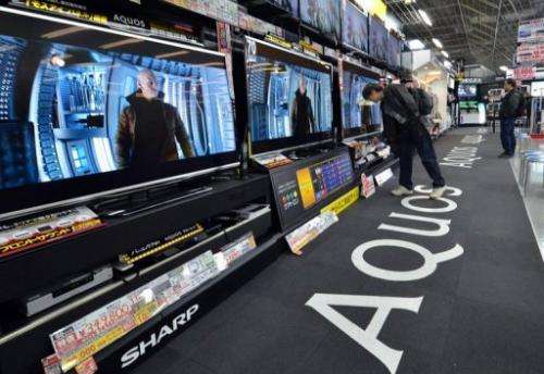 People check out TV sets by Japanese electronics maker Sharp at an electronics shop in Tokyo, on March 6, 2013