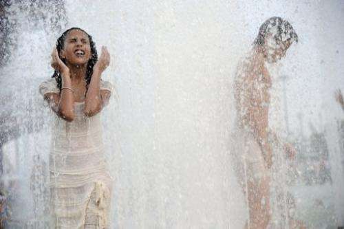 People cool off in the water of the Trocadero's fountains on August 19, 2012 in Paris