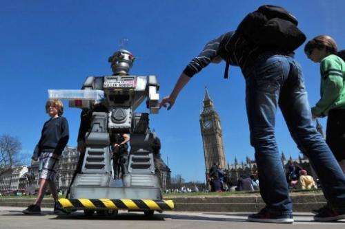 People look a mock &quot;killer robot&quot; in London on April 23, 2013 during the launch of the Campaign to Stop &quot;Killer R