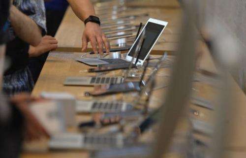 People try out Apple laptops at the opening of the first Apple store in Berlin on May 3, 2013