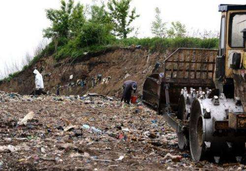 People walk on a landfill site on the outskirts of Polish capital Warsaw on May 24, 2013