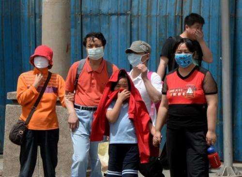 People wear masks to protect against air pollution and dust in Beijing on May 19, 2013