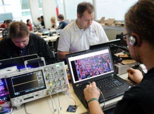 People work on their laptops during an IT convention in Berlin, on December 27, 2011