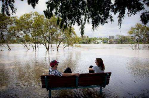 Peter Wilson (left) and Beata Jaremko beside the flooded Brisbane River at West End in Brisbane on January 28, 2013