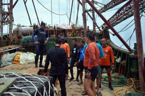 Philippine coast guard personnel inspect the Chinese fishing vessel that ran aground off Tubbataha reef, April 10, 2013