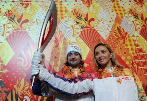 Prominent Russian ice dancers Tatiana Navka (R) and Ilia Averbukh, pose with the Torch in Moscow, on January 14, 2013