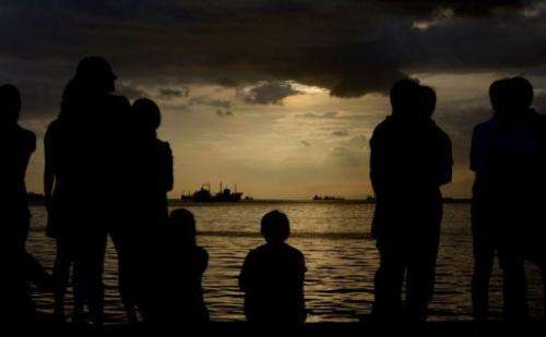 Protesters flock to the water front to watch a cloudy sunset in Manila Bay on February 12, 2013.