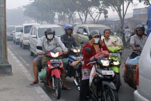Riders wear masks on a road in Pekabaru, Indonesia's Riau province on Sumatra island on June 21, 2013