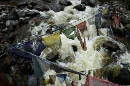 River flows under prayer flags on its way to the Chukha hydropower plant, in south-eastern Bhutan, on May 29, 2013