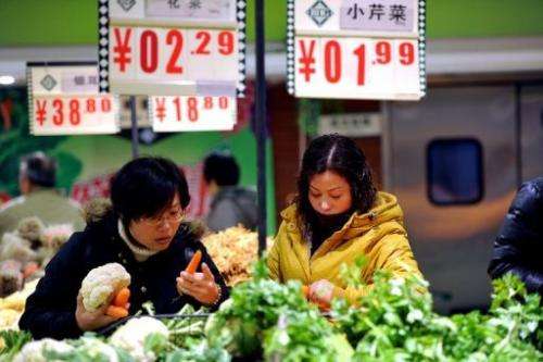 Shoppers buy vegetables at a supermarket in Hefei, east China's Anhui province on December 9, 2012