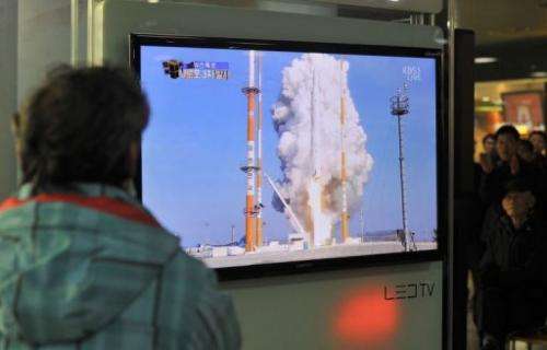 South Koreans watch live footage of the country's rocket launch, at a railway station in Seoul on January 30, 2013