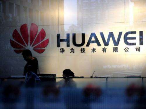 Staff and visitors walk pass the lobby at the Huawei office in Wuhan, central China's Hubei province on October 8, 2012