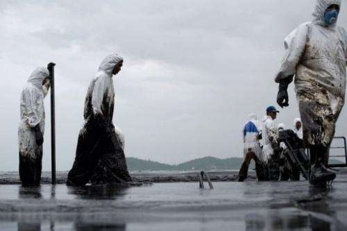 Thai Royal Navy personnel clean Ao Phrao beach on the island of Ko Samet after a major oil slick on July 30, 2013
