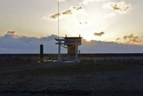 The sun rises behind a shrine to tsunami victims in Minamisoma in Fukushima prefecture on March 11, 2013