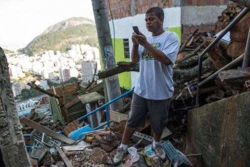 Thiago Firmino takes a picture with his cell phone in Santa Marta shantytown in Rio de Janeiro, Brazil, on June 11, 2013