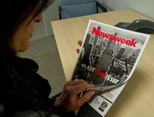 This December 24, 2012 photo shows a woman perusing the final print edition of Newsweek in Washington, DC