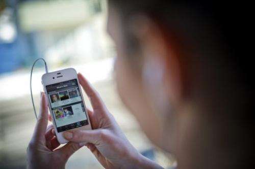 This photo illustration shows a woman using the iPhone application of Swedish music streaming service Spotify.